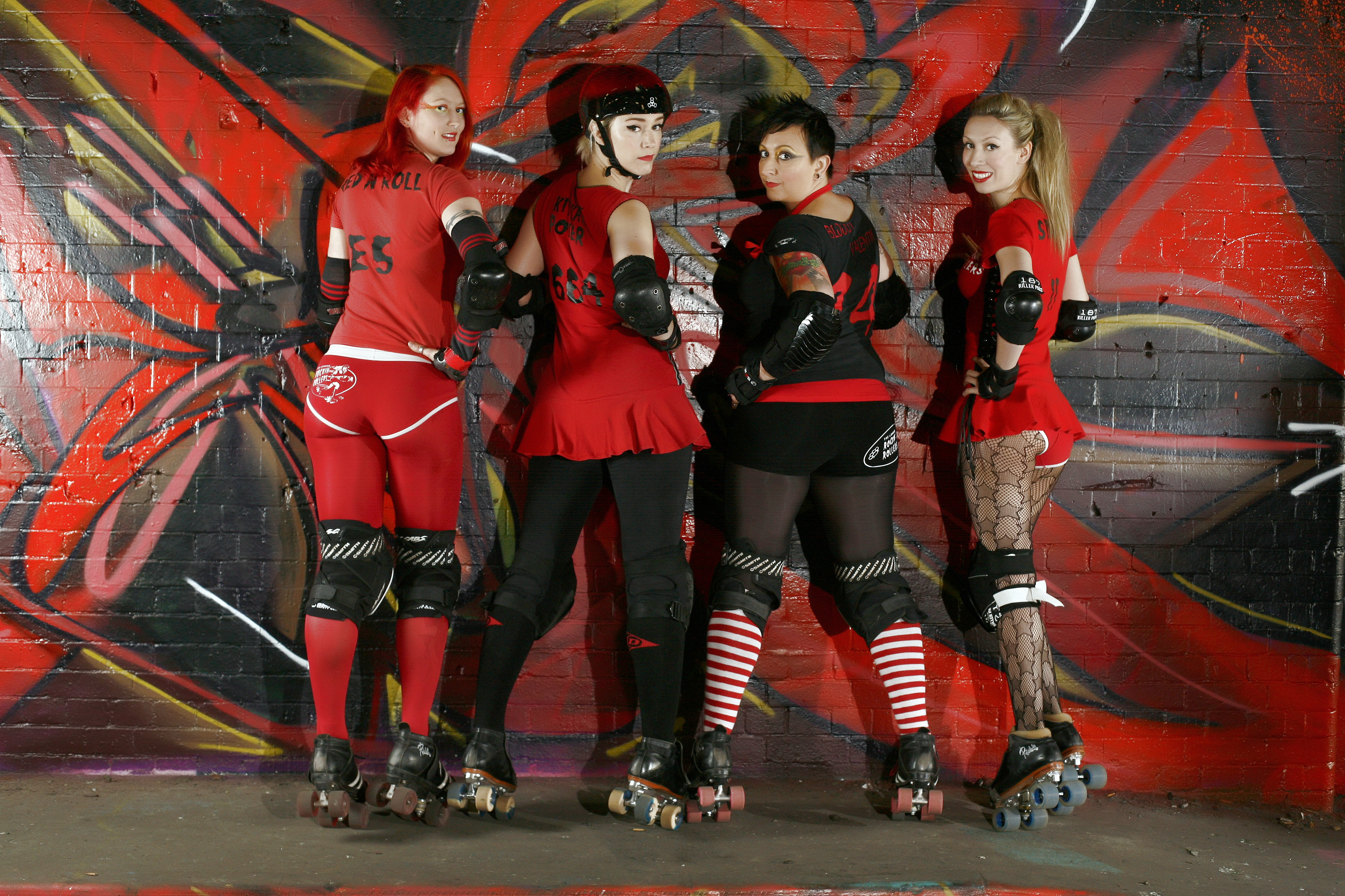 A man in a vintage band tee, ripped jeans, and high-top sneakers, embodying the rugged and rebellious spirit of roller derby fashion.