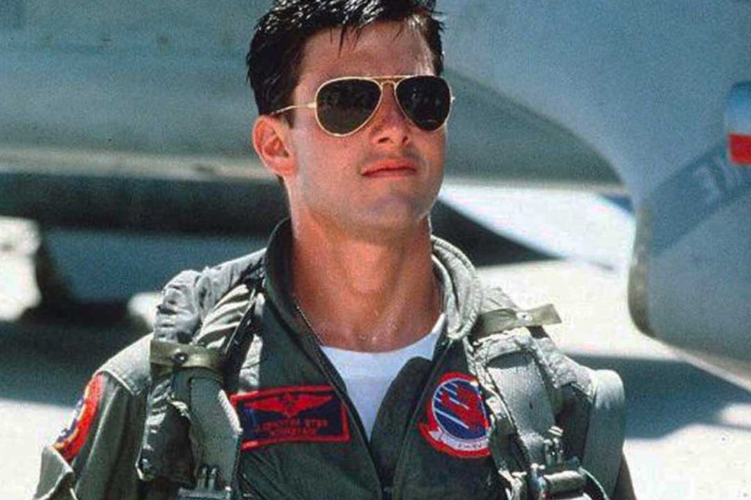 Tom Cruise in the movie Top Gun wearing pilot uniform and wire Aviator sunglasses
