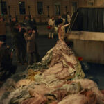 Emma Stone as Cruella De Vil in Disney’s Cruella wearing the Garbage Truck Dress, a rebellious and fashionable statement.