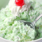 Bowl of green pistachio fluff salad with a spoon