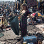 Man in tie-dye shirt with guitar at Woodstock