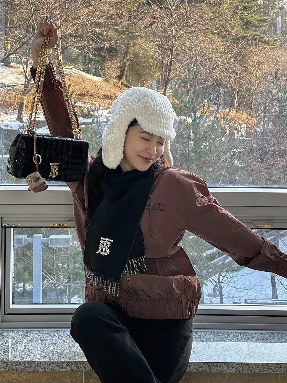 Red Velvet's Yeri in Ushanka hat, warm jacket and black scarf exuding elegance and warmth with contrasting white knit Ushanka hat.