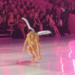 Model Doutzen Kroes adjusting her shoe on the runway at the Victoria's Secret Fashion Show in Brooklyn